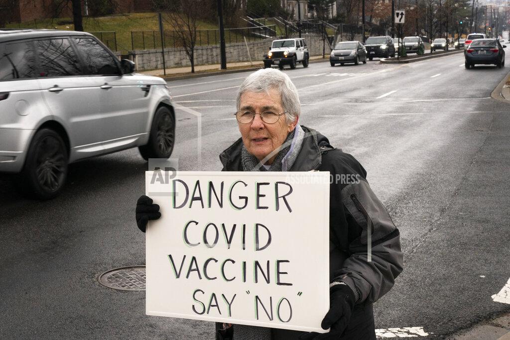 Jacquelyn Martin In this Thursday, Feb. 11, 2021, photo Kathy Boylan, 77, of Washington, who says she has never received any vaccinations herself, protests the COVID-19 vaccine, Thursday, Feb. 11, 2021, outside the Pennsylvania Avenue Baptist Church that was hosting a vaccination clinic in southeast Washington. (AP Photo/Jacquelyn Martin)
