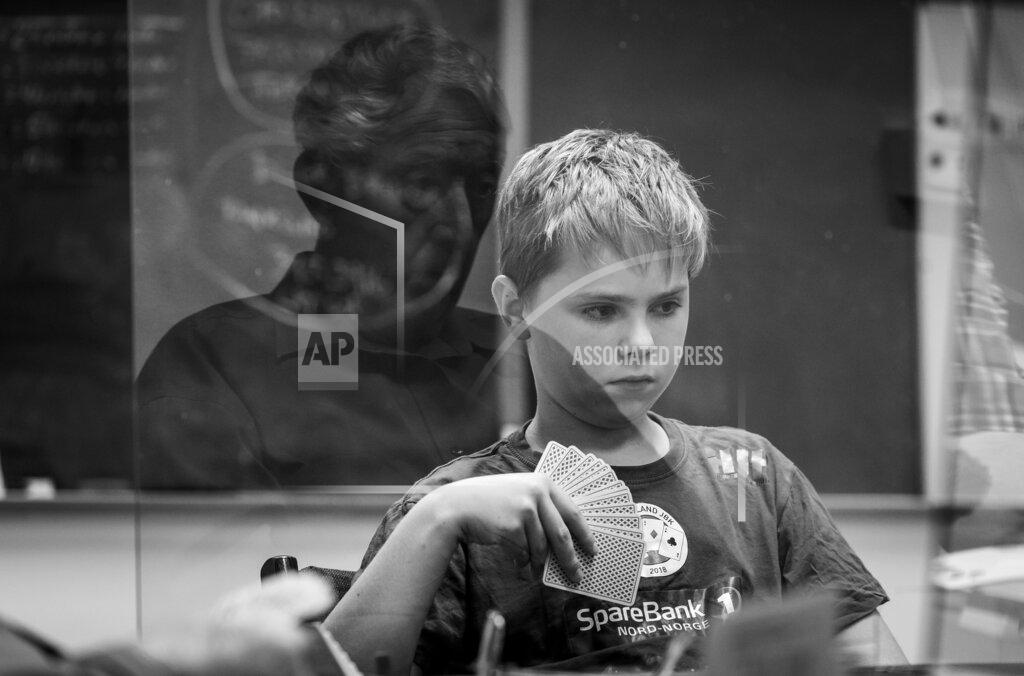 Henrik Hansson In this image released by World Press Photo, Thursday April 15, 2021, by Henrik Hansson, titled Faces of Bridge, part of a series which won second prize in the Sports Stories category, shows An 11-year-old boy plays a 92-year-old man, at the Borlange Bridge Club, Borlange, Sweden, on 28 June 2020. (Henrik Hansson, World Press Photo via AP)