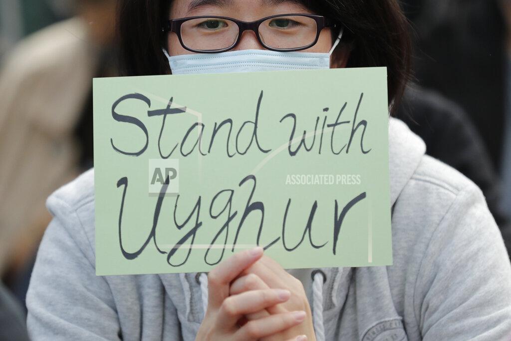 Lee Jin-Man FILE - In this Dec. 22, 2019, file photo, a man holds a sign during a rally to show support for Uighurs and their fight for human rights in Hong Kong. People from western China who are targets of a Chinese government crackdown say they have been threatened and harassed in the United States. Those fleeing the crackdown on the predominantly Muslim Uighur ethnic group typically receive U.S. asylum. But Uighurs tell The Associated Press and human rights groups they still afraid amid threats aimed at them and their families back in China. (AP Photo/Lee Jin-man, File)