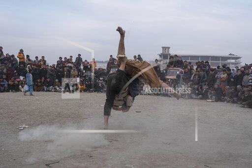 Afghan men wrestle in Kabul, Afghanistan, Friday, Dec. 3 , 2021. The scene is one played out each week after Friday prayers in the sprawling Chaman-e-Huzori park in downtown Kabul, where men, mainly from Afghanistan's northern provinces, gather to watch and to compete in pahlawani, a traditional form of wrestling. (AP Photo/ Petros Giannakouris)