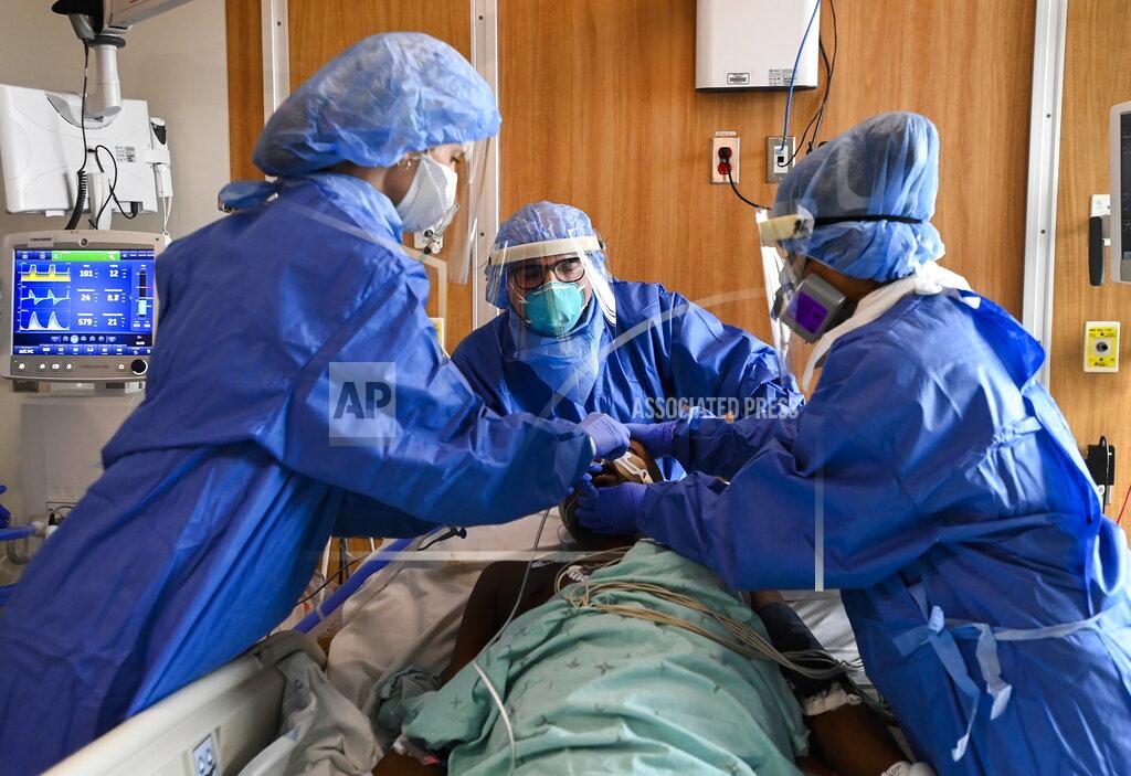 Health care staff provide life saving medical care to 60-year-old COVID-19 patient in the intensive care unit at the Humber River Hospital in Toronto on Tuesday, April 13, 2021. The patient was intubated and put on a ventilator successfully. (Nathan Denette/The Canadian Press via AP)