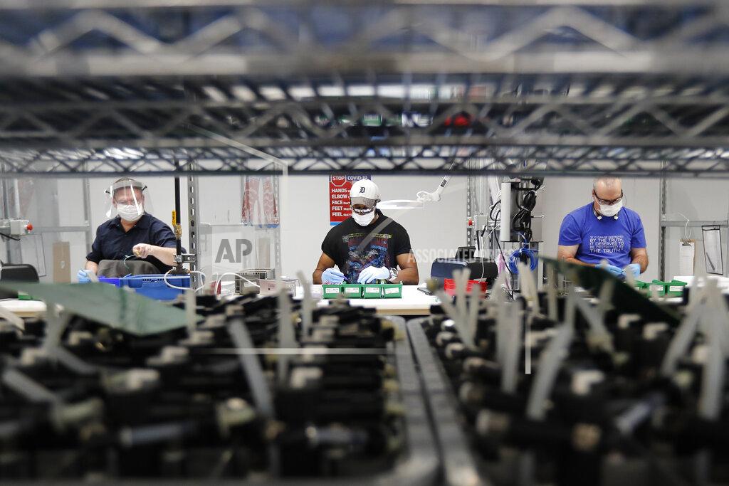 FILE - In this May 13, 2020, file photo, Ford Motor Co., line workers put together ventilators that the automaker is assembling at the Ford Rawsonville plant in Ypsilanti Township, Mich. Severe winter weather pushed industrial production down a sharp 2.2% in February, reflecting a big decline in factory output. The Federal Reserve reported Tuesday, March 16, 2021, that the sharp fall in industrial output interrupted a string of positive gains beginning in October as U.S. factories were recovering from the pandemic-induced recession of last spring. (AP Photo/Carlos Osorio, File)