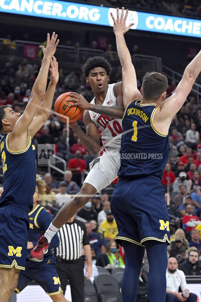 David Becker UNLV guard Keshon Gilbert (10) looks to pass against as Michigan's Hunter Dickinson, right, and Caleb Houstan defend during the first half of an NCAA college basketball game Friday, Nov. 19, 2021, in Las Vegas. (AP Photo/David Becker)