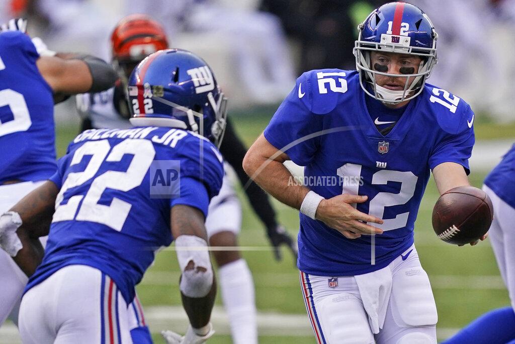 Bryan Woolston New York Giants quarterback Colt McCoy (12) hands off the ball to running back Wayne Gallman (22) during the second half of an NFL football game against the Cincinnati Bengals, Sunday, Nov. 29, 2020, in Cincinnati. (AP Photo/Bryan Woolston)
