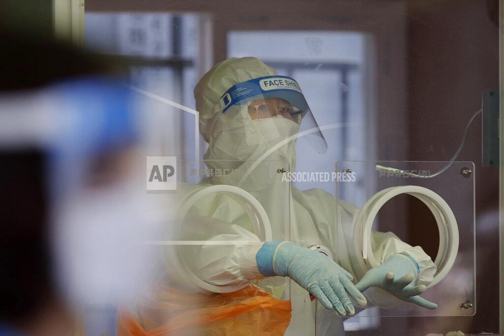 Lee Jin-Man A medical worker wearing protective gear prepares to take a sample at a temporary screening clinic for coronavirus in Seoul, South Korea, Saturday, April 10, 2021. (AP Photo/Lee Jin-man)
