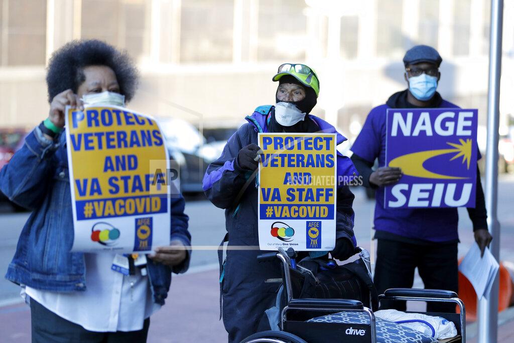Clarence Shields, center, an Army veteran, pickets with a small group of activists from the American Federation of Government Employees local 424 and the National Association of Government Employees local R3-19 outside the Baltimore VA Medical Center, Wednesday, April 22, 2020, in Baltimore. The Department of Veterans Affairs is struggling with shortages of workers at its health care facilities as it cares for veterans infected with the novel coronavirus. (AP Photo/Julio Cortez)