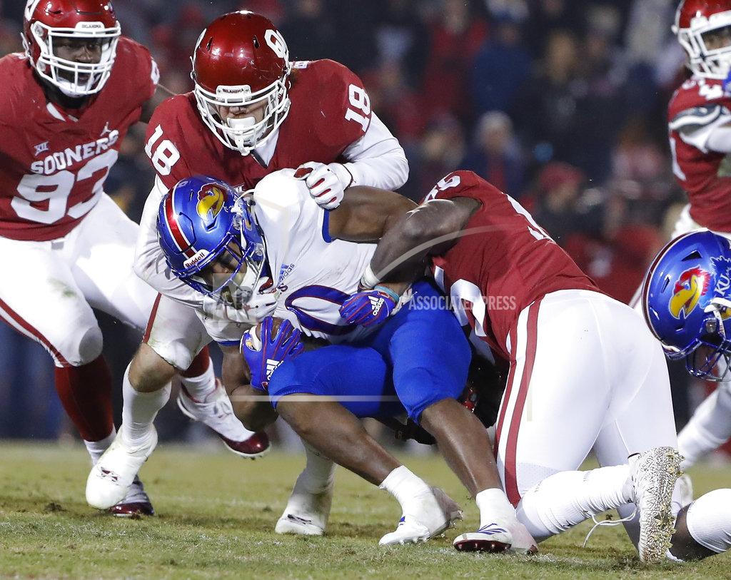 Alonzo Adams Kansas running back Khalil Herbert, center, is tackled by Oklahoma defensive lineman Kenneth Mann, right, and Oklahoma linebacker Curtis Bolton, left, during the second half of an NCAA college football game in Norman, Okla., Saturday, Nov. 17, 2018. Oklahoma won 55-40. (AP Photo/Alonzo Adams)