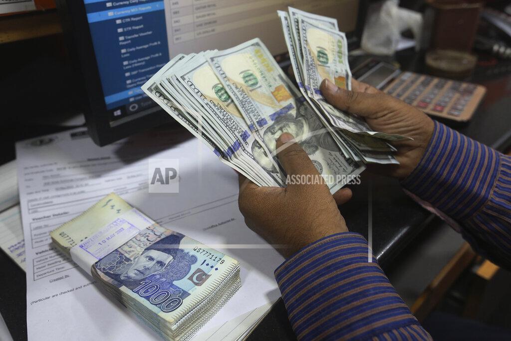 Fareed Khan A Pakistani money trader counts U.S. dollars for a customer at a currency exchange office, in Karachi, Pakistan, Thursday, May 19, 2022. Pakistan’s currency has plummeted to an all-time record low in intraday trading against the U.S. dollar amid uncertainty about the success of crucial talks between the International Monetary Fund and the government of Prime Minister Shahbaz Sharif, which is considering massive new taxation to avoid a default. (AP Photo/Fareed Khan)