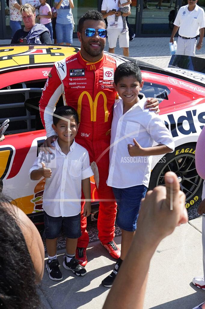 Charles Rex Arbogast NASCAR driver Bubba Wallace poses with two youngsters at Navy Pier on Tuesday, July 19, 2022, Chicago during a promotional visit to announce a Cup Series street race to be held July 2, 2023, in the city. (AP Photo/Charles Rex Arbogast)
