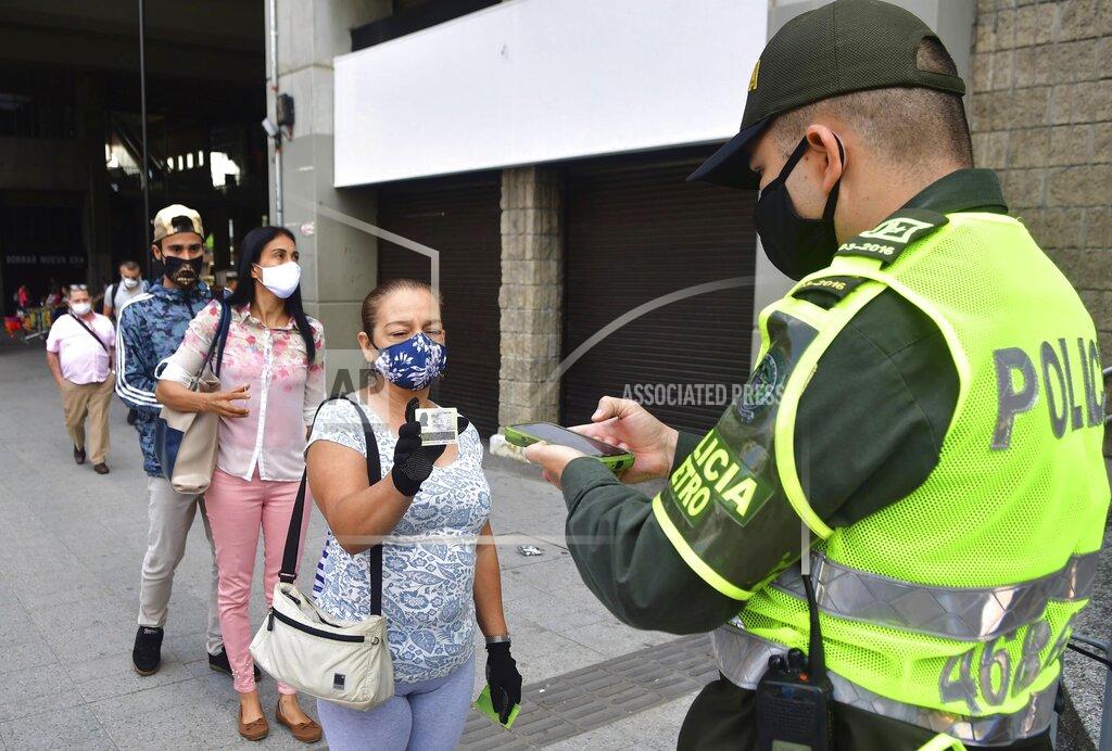 Luis Benavides In this June 8, 2020 photo, a police officer uses a newly developed software to scan the identification card which determines if a resident has the authorization to be out in public, amid the new coronavirus pandemic, in Medellin, Colombia. Critics of the city’s mayor fear the immense data being collected on citizens amounts to a severe invasion of privacy, but even they admit that it has proven effective in containing COVID-19. (AP Photo/Luis Benavides)