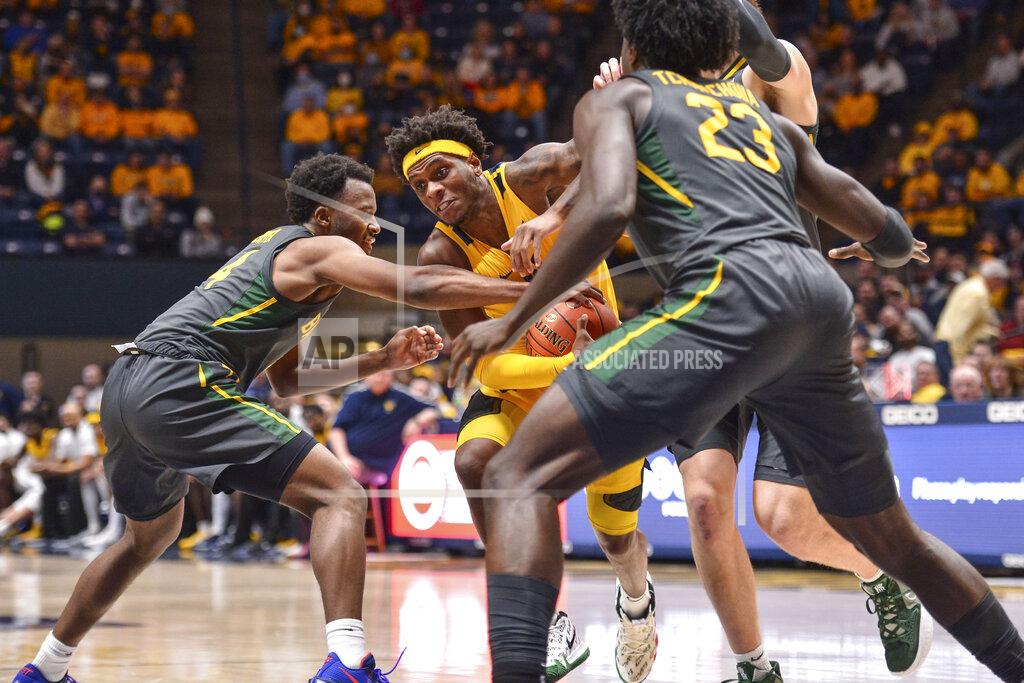 William Wotring West Virginia guard Malik Curry (10) protects the ball from Baylor guard LJ Cryer (4) during the first half of an NCAA college basketball game in Morgantown, W.Va., Tuesday, Jan. 18, 2022. (William Wotring)