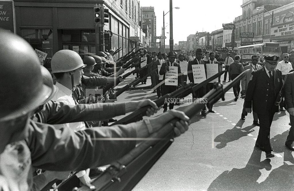 Charlie Kelly FILE - In this March 29, 1968, file photo, striking Memphis sanitation workers march past Tennessee National Guard troops with fixed bayonets during a 20-block march to City Hall in Memphis, Tenn. A national coalition of labor unions, along with racial and social justice organizations, will stage a mass walkout from work July 20, as part of an ongoing reckoning on systemic racism and police brutality in the U.S. The strike will continue a decades-old tradition of the American labor rights movement and most notably, organizers draw inspiration from the historic Memphis sanitation workers’ strike. (AP Photo/Charlie Kelly, File)