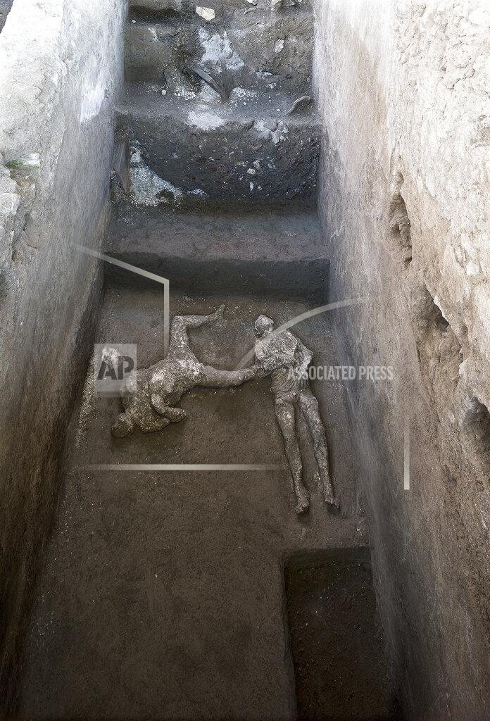 Uncredited The casts of what are believed to have been a rich man and his male slave fleeing the volcanic eruption of Vesuvius nearly 2,000 years ago, are seen in what was an elegant villa on the outskirts of the ancient Roman city of Pompeii destroyed by the eruption in 79 A.D., where they were discovered during recents excavations, Pompeii archaeological park officials said Saturday, Nov. 21, 2020. (Parco Archeologico di Pompei via AP)