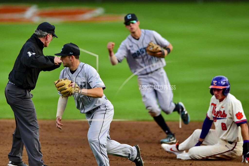 Richard Shiro FILE - In this Wednesday, March 13, 2019, file photo, Coastal Carolina's Cory Wood, left, and Scott McKeon, center, react after tagging Clemson's Logan Davidson, right, out at second base during an NCAA college baseball game, in Clemson, S.C. Coastal Carolina already had a small athletic budget, and that was before a 15% spending cut was ordered because of projected declines in state funding and student fees stemming from the coronavirus pandemic. The school's 19-sport program includes about 450 athletes, and with individual tests currently costing about $100, testing could cost hundreds of thousands of dollars by the end of the 2020-21 academic year. (AP Photo/Richard Shiro, File)