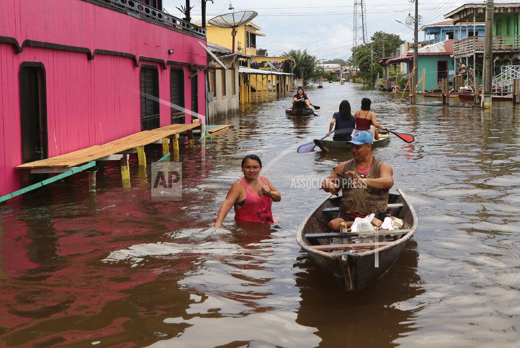 Edmar Barros Residents navigate flooded streets in Anama, Amazonas state, Brazil, Thursday, May 13, 2021. (AP Photo/Edmar Barros)