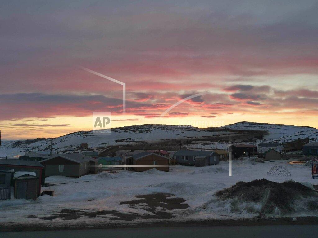 Aaron Watson In this May 7, 2020 photo provided by Aaron Watson, the sun sets over Iqaluit, the capital of Nunavut territory in far north Canada. Iqaluit has a population of about 7,000 people, many of whom are Inuit. Watson says, so far, there are no cases of coronavirus in the town. (AP Photo via Aaron Watson)