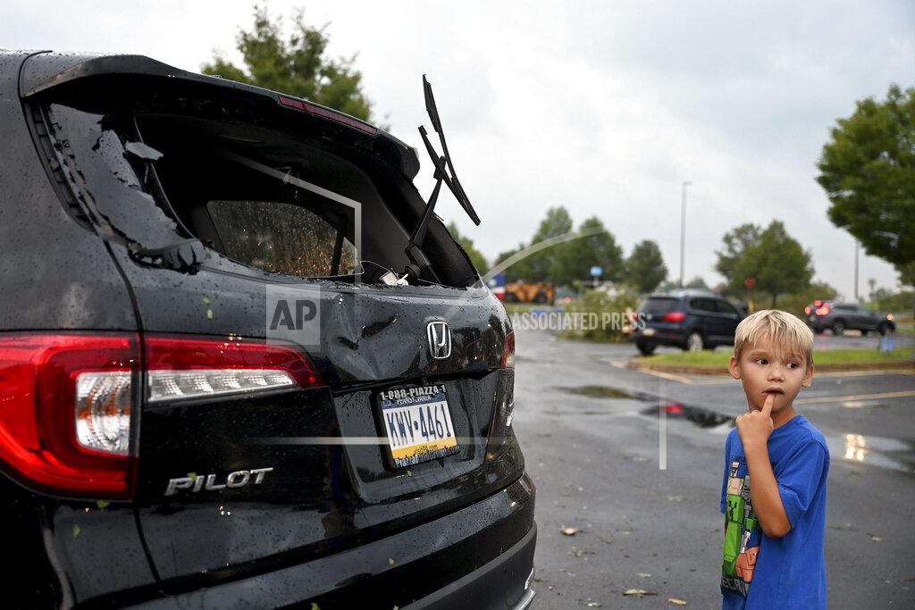 Tom Gralish Storm damage to car is seen in a parking lot at the Walmart and Lowe's in Trevose, Pa. Thursday, July 29, 2021. Five people were injured Thursday when a building at a Bensalem auto dealership was destroyed by severe weather, authorities said. The National Weather Service confirmed two tornados touched down in Bucks County, sending trees falling and debris flying.(Tom Gralish/The Philadelphia Inquirer via AP)