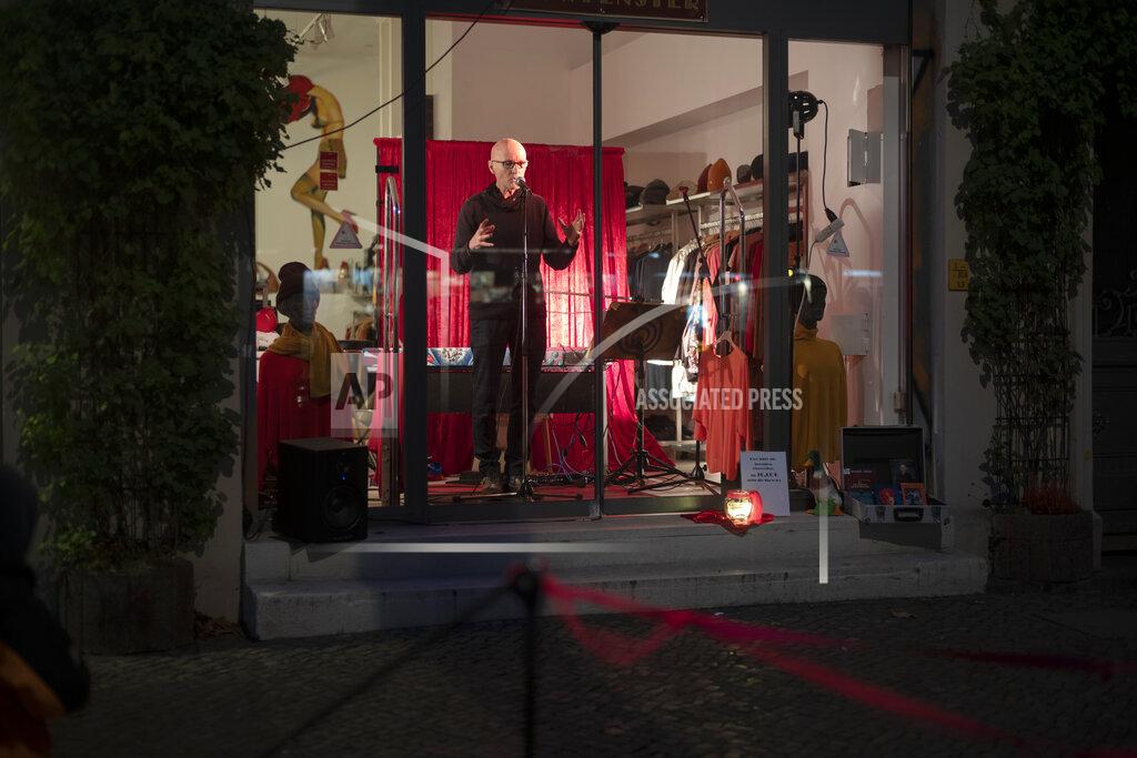 Gerd Norman from a group of independent artists known as Entenfuss Kultur, Duck's Foot Culture, performes at a so-called 'Show Windows' at the district Prenzlauer Berg in Berlin, Germany, Sunday, Dec. 6, 2020. With theaters and concert halls shuttered to prevent the spread of the coronavirus, some Berlin artists are taking their performances to the streets of the German capital in an effort to keep their edge during the pandemic and feed a population starved for cultural interaction. (AP Photo/Markus Schreiber)