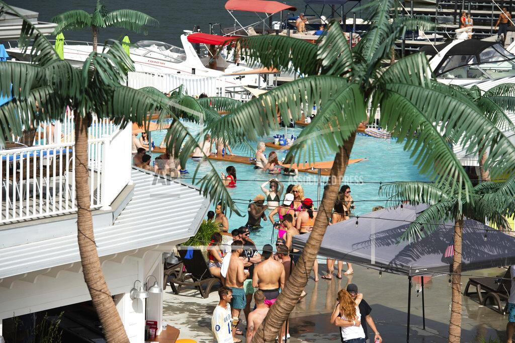 Shelly Yang FILE- In this Sunday, May 24, 2020 file photo crowds of people gather at Coconuts Caribbean Beach Bar & Grill in Gravois Mills, Mo. Several counties in southern Missouri are seeing a big rise in COVID-19 cases and hospitalizations. Those areas include Branson and Lake of the Ozarks, which are popular among tourists. (Shelly Yang/The Kansas City Star via AP)