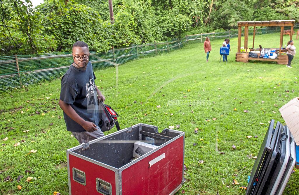 Ben Braun Rev. Michael Day goes though a container of audio equipment to set up for worship service on Wednesday, Aug. 18, 2021, in Northview Heights in Pittsburgh. making it his mission to work with the city and group violence outreach workers to address the needs of families in Northview Heights. He and church members planned to set up a tent in the neighborhood and try to connect residents to counseling, basic necessities and church ministries. (Ben Braun/Pittsburgh Post-Gazette via AP)