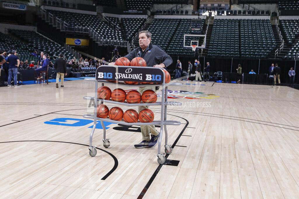 Basketballs are removed from the court at Bankers Life Fieldhouse, in Indianapolis, Thursday, March 12, 2020, after the Big Ten Conference announced that remainder of the men's NCAA college basketball games tournament was cancelled. (AP Photo/Michael Conroy)