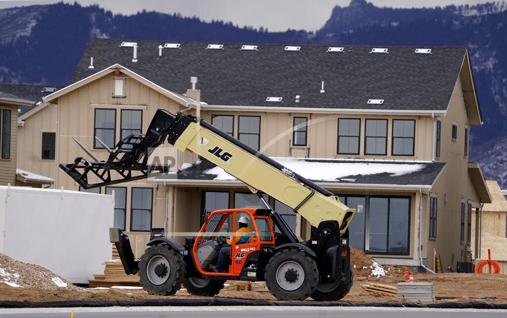 FILE - In this Dec. 1, 2020 file photo, workers toil on new homes under construction in a development near Chatfield State Park in Littleton, Colo. Spending on U.S. construction projects increased 0.9% in November as strength in home building offset weakness in other parts of the construction industry. The Commerce Department said that the November gain followed a bigger 1.6% rise in October and left construction spending up 4.4% through the first 11 months of 2020 compared to the same period in 2019. (AP Photo/David Zalubowski, File)