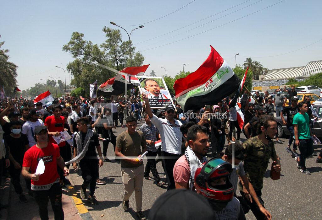 Khalid Mohammed Anti-government protesters chant slogans as they hold posters of slain activist Ehab Wazni outside the Green Zone area which houses the seat of the country's government and foreign embassies, in Baghdad, Iraq, Tuesday, May 25, 2021. Hundreds of Iraqi protesters have taken to the streets of Baghdad to decry a recent spike in assassinations targeting outspoken activists and journalists. (AP Photo/Khalid Mohammed)