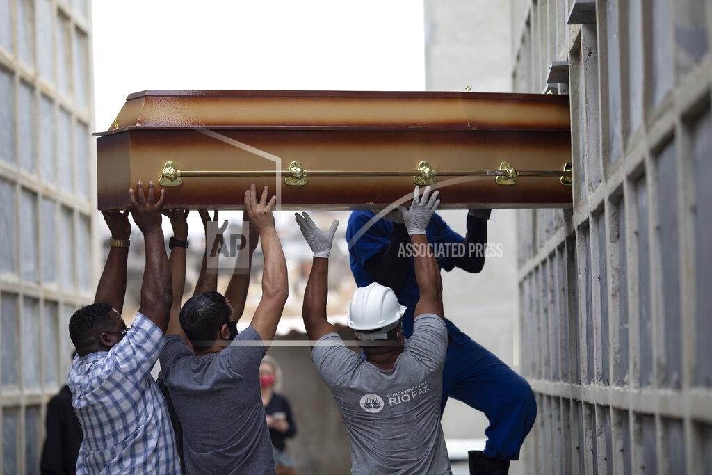 Silvia Izquierdo FILE - In this April 13, 2021 file photo, the remains of a woman who died from complications related to COVID-19 are placed into a niche by cemetery workers and relatives at the Inahuma cemetery in Rio de Janeiro, Brazil. As Brazil hurtles toward an official COVID-19 death toll of 500,000, epidemiologists at the University of Sao Paulo say the true toll is closer to 600,000, maybe 800,000. (AP Photo/Silvia Izquierdo, File)