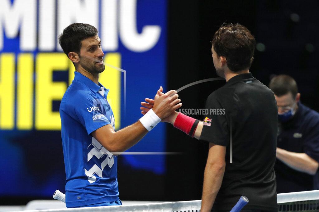 Frank Augstein Novak Djokovic of Serbia, left, shakes hands with Dominic Thiem of Austria at the of their semifinal match ATP World Finals tennis tournament at the O2 arena in London, Saturday, Nov. 21, 2020. Thiem beat the top-ranked Djokovic 7-5, 6-7 (10), 7-6 (5). (AP Photo/Frank Augstein)