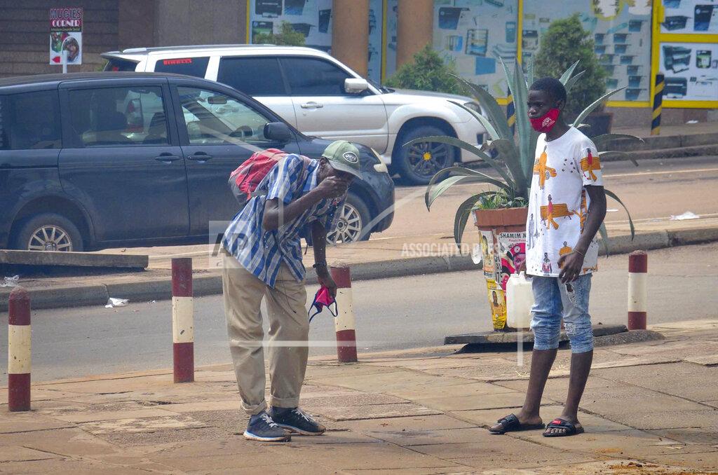 A man splashes his face with water after being affected by tear gas during clashes between security forces and protesters supporting opposition presidential candidate Bobi Wine, in downtown Kampala, Uganda Wednesday, Nov. 18, 2020. Protests have broken out in Uganda's capital after police arrested Bobi Wine, a musician and opposition politician who is seeking the presidency in next year's election. (AP Photo)