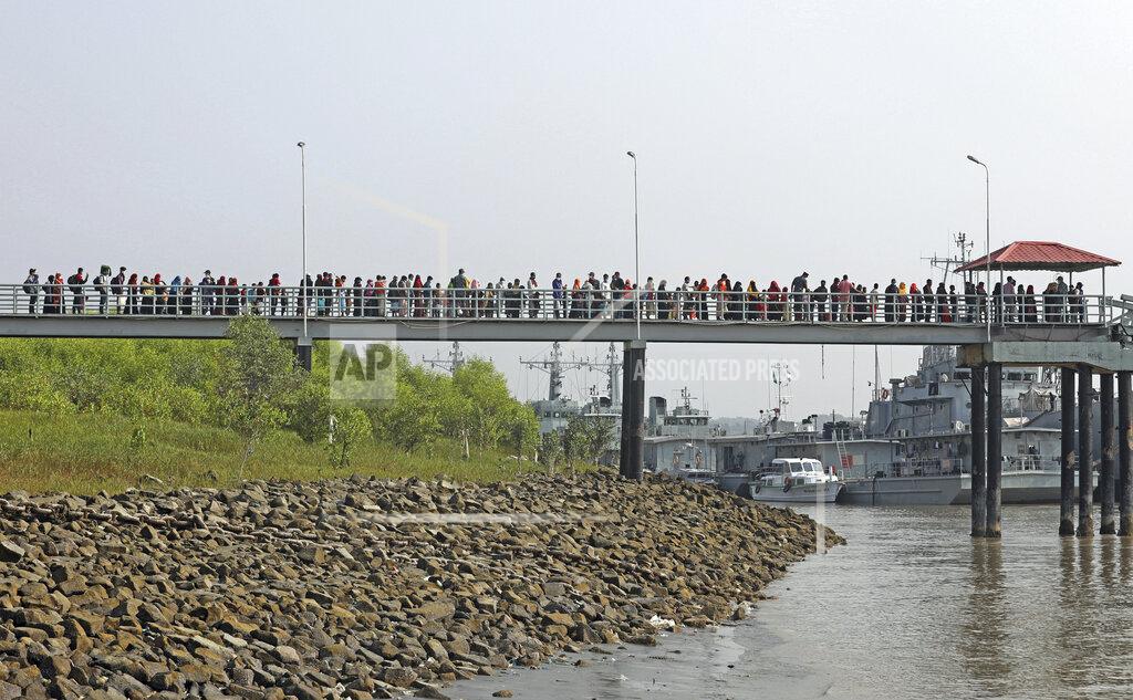 Uncredited Rohingya refugees walk to a naval vessel to be transported to Bhashan Char, or floating island, in the Bay of Bengal, from Chittagong, Bangladesh, Friday, Dec. 4, 2020. Authorities in Bangladesh on Friday started sending a first group of nearly more than 1,500 Rohingya refugees to an isolated island despite calls by human rights groups for a halt to the process. (AP Photo).