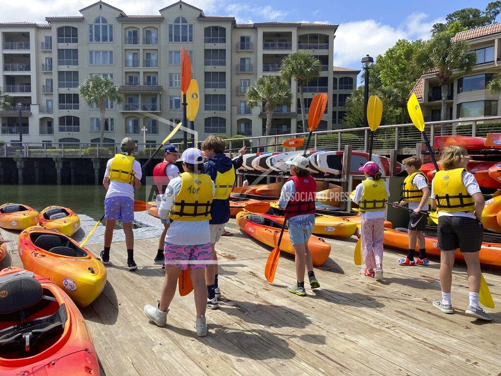 Sarah Haselhorst Students from Hilton Head Christian Academy gearing up with life jackets and paddles before making a kayaking excursion on the Broad Creek to learn about the environment Monday, May 9, 2022 on Hilton Head Island. (Sarah Haselhorst/The Island Packet via AP)