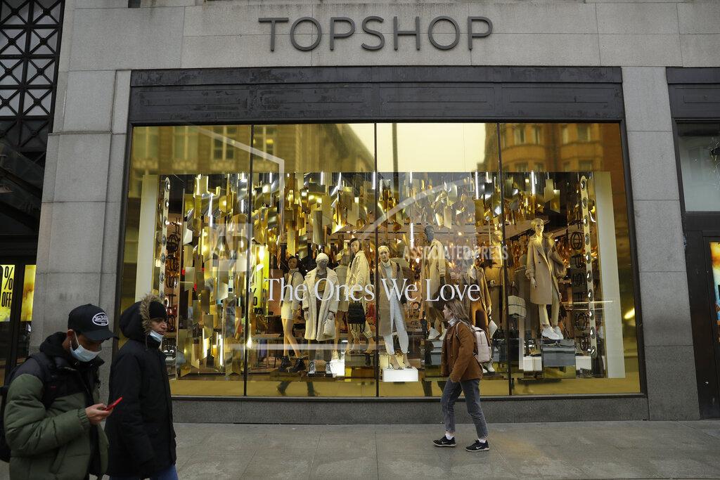 Matt Dunham People wearing face masks to try to curb the spread of coronavirus walk past the temporarily closed Topshop flagship store on Oxford Street, during England's second coronavirus lockdown, in London, Monday, Nov. 30, 2020. Arcadia Group, the retail empire of tycoon Philip Green, which owns well-known British fashion chains like Topshop and employs around 15,000 people, appears to be on the brink of collapse following the economic shock of the coronavirus pandemic. (AP Photo/Matt Dunham)