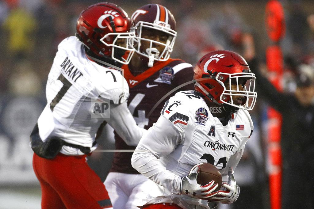 Patrick Semansky Cincinnati safety James Wiggins, right, intercepts a pass-attempt intended for Virginia Tech wide receiver Damon Hazelton, back center, in the final moments of the Military Bowl NCAA college football game, Monday, Dec. 31, 2018, in Annapolis, Md. Cincinnati cornerback Coby Bryant (7) looks on. (AP Photo/Patrick Semansky)