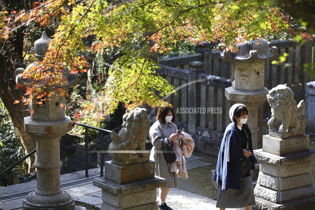 Koji Sasahara Visitors wearing face masks to protect against the spread of the coronavirus walk through the colorful autumn leaves at the Kenchoji temple in Kamakura, Monday, Nov. 30, 2020. (AP Photo/Koji Sasahara)
