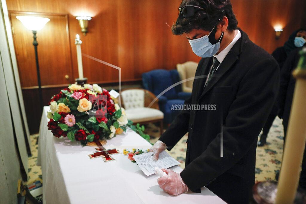 John Minchillo Leonardo Cabana cries over the casket of his father Hector Cabana who died of COVID-19 after a funeral home service given by Fabian Arias, a Lutheran pastor with Saint Peter's Church in Manhattan, Monday, May 11, 2020, in the Brooklyn borough of New York. (AP Photo/John Minchillo)