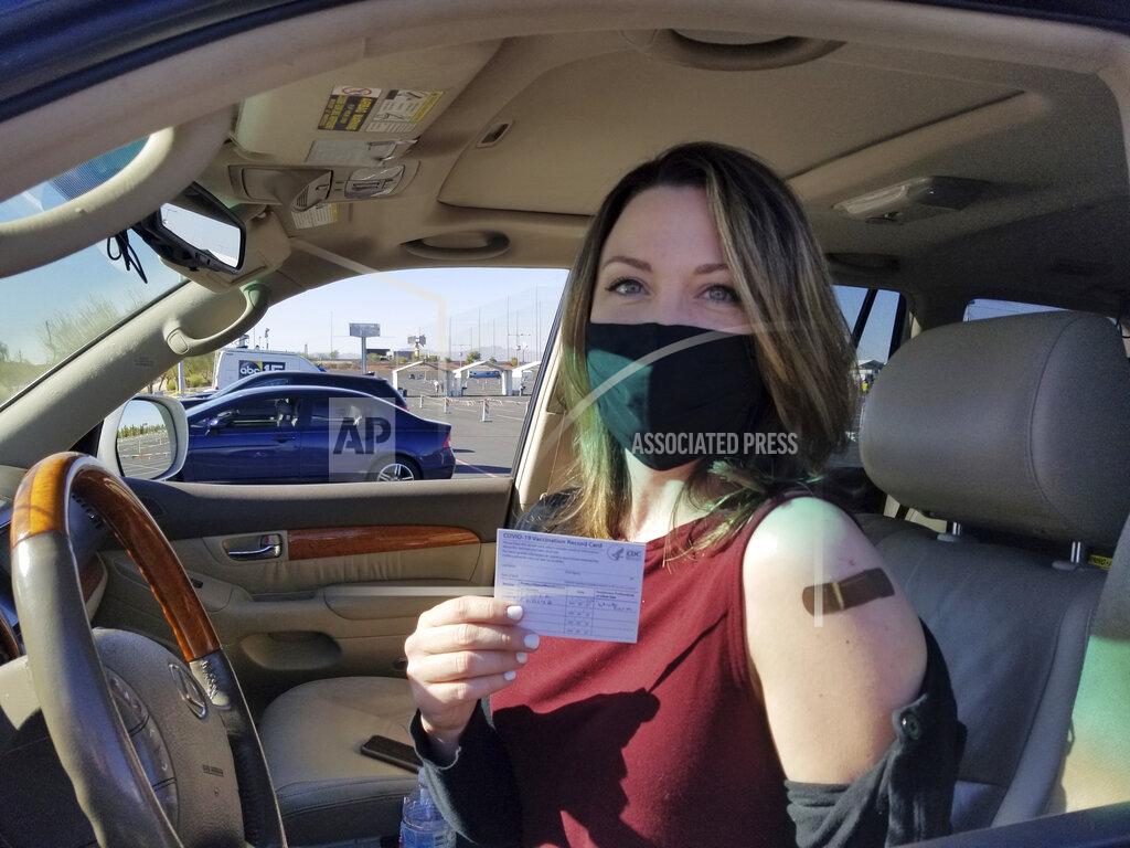 Terry Tang Emily Alexander, 37, shows her COVID-19 vaccination card shortly after getting the vaccine in the parking lot of the State Farm Stadium in Glendale, Ariz., on Monday, Jan. 11, 2021. The Arizona Cardinals' stadium opened as a vaccination site Monday that will be a 24-7 operation. (AP Photo/Terry Tang)
