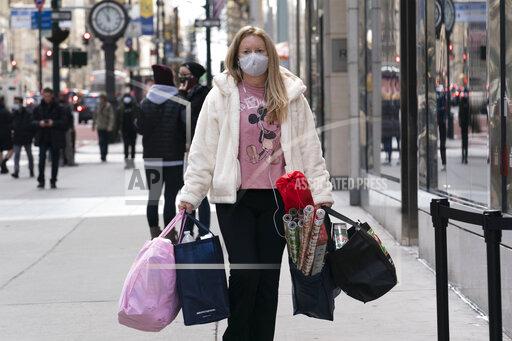 FILE - In this Dec. 10, 2020 file photo, a woman carries shopping bags in New York. The National Retail Federation expects that holiday sales gain could shatter last year’s record-breaking season even as a snarled global supply chain slows the flow of goods and results in higher prices for broad range of items. The nation's largest retail trade group said Wednesday, Oct. 27, 2021 it predicts that sales for the November and December period will grow between 8.5% and 10.5% to $843.4 billion and $859 billion. (AP Photo/Mark Lennihan, File)