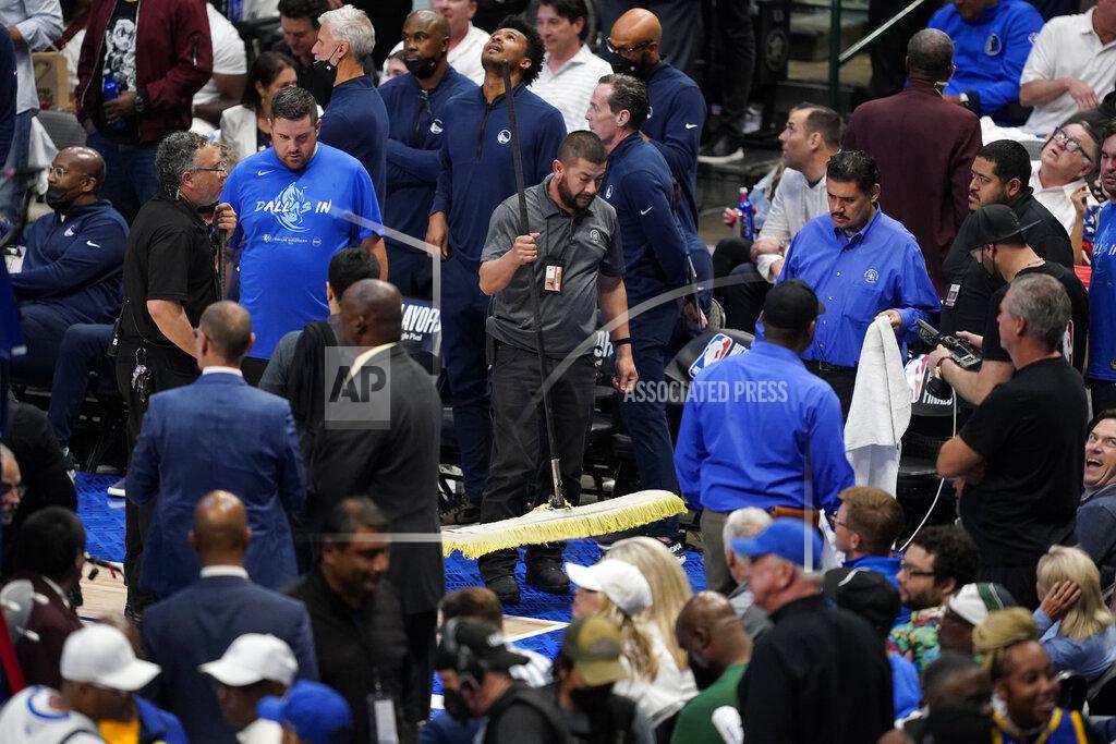 Tony Gutierrez Officials help soak up a rain leak from the American Airlines Center roof during the second half of Game 4 of the NBA basketball playoffs Western Conference finals between the Dallas Mavericks and the Golden State Warriors, Tuesday, May 24, 2022, in Dallas. (AP Photo/Tony Gutierrez)