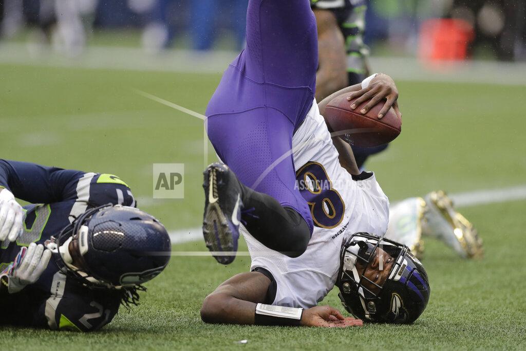 John Froschauer Baltimore Ravens quarterback Lamar Jackson (8) comes down next to Seattle Seahawks cornerback Tre Flowers, left, as he scores a touchdown on a fourth-down keeper play during the second half of an NFL football game, Sunday, Oct. 20, 2019, in Seattle. (AP Photo/John Froschauer)