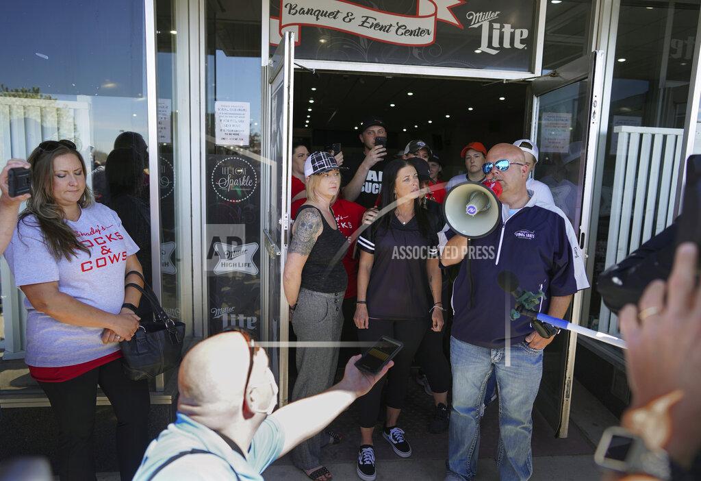 Brian Peterson Kris Schiffler, right, the owner of Shady's Hometown Tavern in Albany, Minn. tells supporters outside his business that he's not opening his bar and grill Monday, May 18, 2020, on the advice of his attorney, after getting a call from Minnesota Attorney General Keith Ellison. (Brian Peterson/Star Tribune via AP)