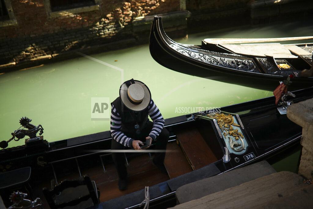 Francisco Seco A gondolier looks at his smartphone as he waits for clients in Venice, Italy, Friday, Feb. 28, 2020, during the coronavirus outbreak. (AP Photo/Francisco Seco)