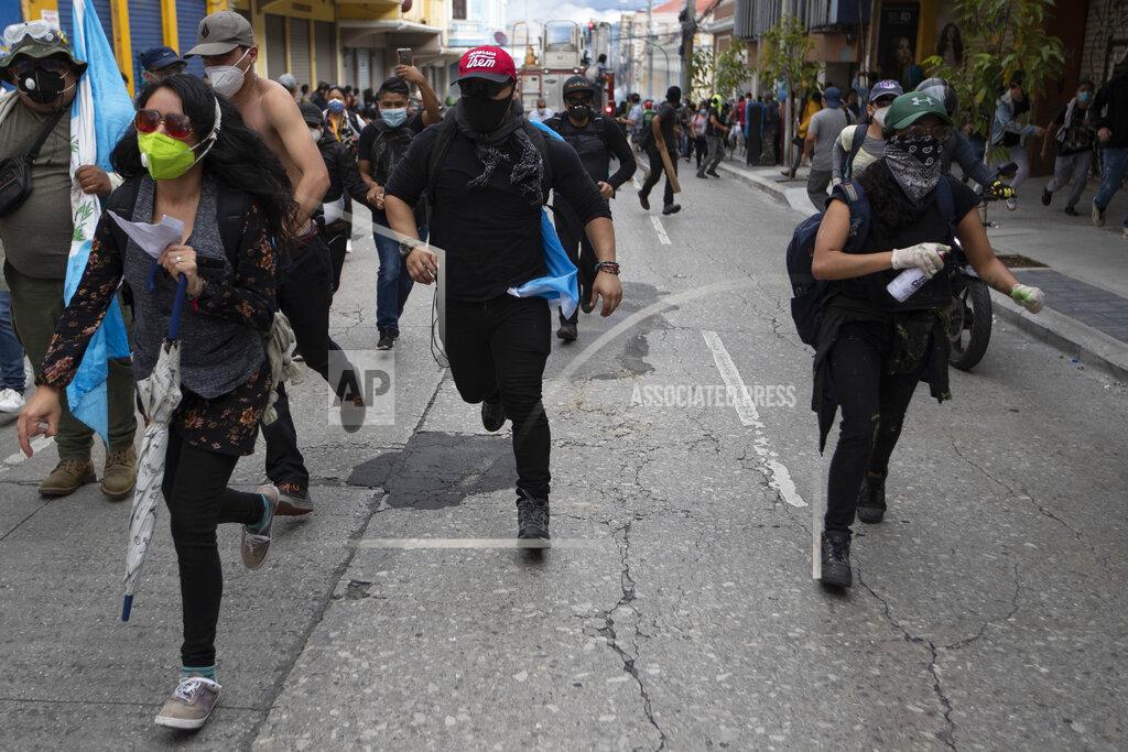 Oliver De Ros Protestors take chase from advancing police after protesters set a part of the Congress building on fire, in Guatemala City, Saturday, Nov. 21, 2020. Hundreds of protesters were protesting in various parts of the country Saturday against Guatemalan President Alejandro Giammattei and members of Congress for the approval of the 2021 budget that reduced funds for education, health and the fight for human rights. (AP Photo/Oliver De Ros)