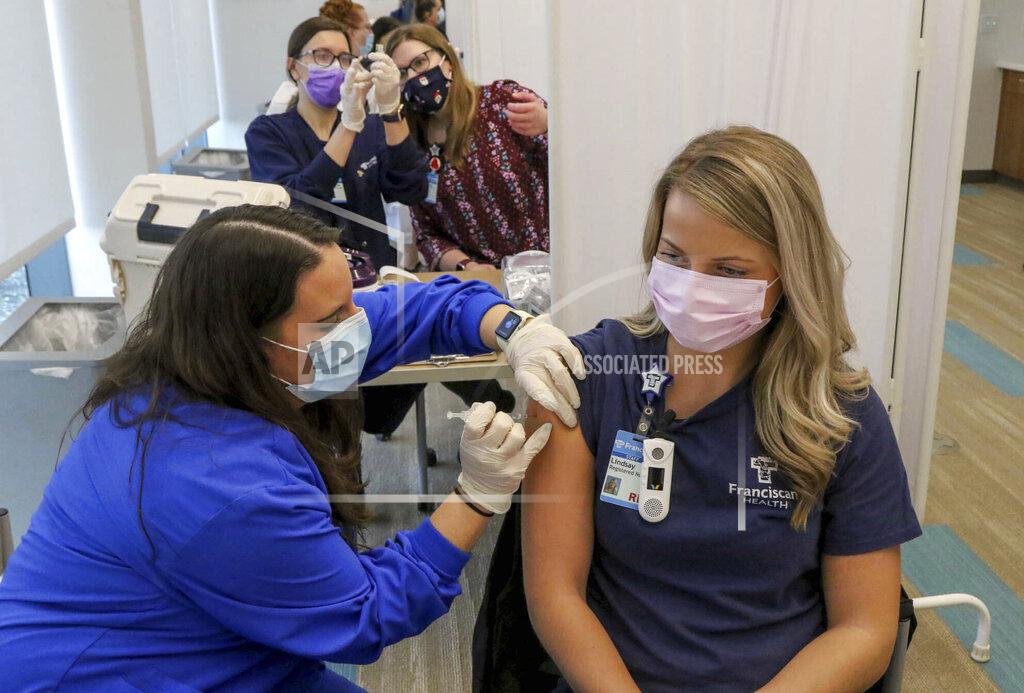 John Luke Certified Nurse Assistant Kisa Kniola, left, gives a COVID-19 vaccination to Registered Nurse Lindsay Kreighbaum at Franciscan Health, Friday, Dec. 18, 2020, in Michigan City, Ind. (John Luke/The Times via AP)