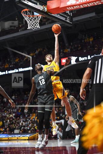 Minnesota forward Jamison Battle (10) scores on a layup after he was fouled by Jacksonville forward Mike Marsh (12) during the first half of an NCAA college basketball game Wednesday, Nov. 24, 2021, in Minneapolis. (Aaron Lavinsky/Star Tribune via AP)
