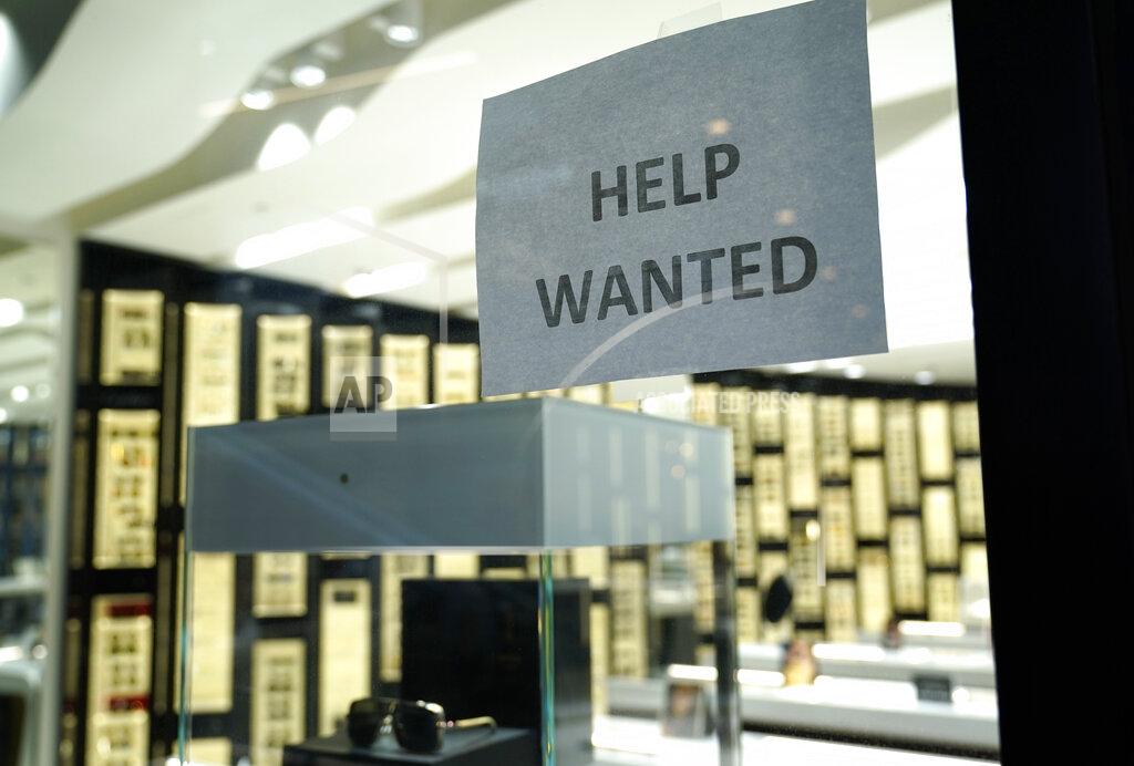 Lynne Sladky A Help Wanted sign is posted at a Designer Eyes store at Brickell City Centre, Friday, Nov. 6, 2020, in Miami. Defying fears of another slowdown, U.S. businesses kept hiring at a solid pace in October yet there are signs they remain cautious about the economy's future as the pandemic worsens. (AP Photo/Lynne Sladky)