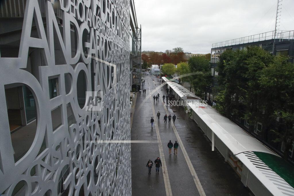 Michel Euler Closed sponsor stands and souvenirs shops are seen right, as few spectators walk the alley outside center court, left, during first round matches of the French Open tennis tournament at the Roland Garros stadium in Paris, France, Sunday, Sept. 27, 2020. (AP Photo/Michel Euler)