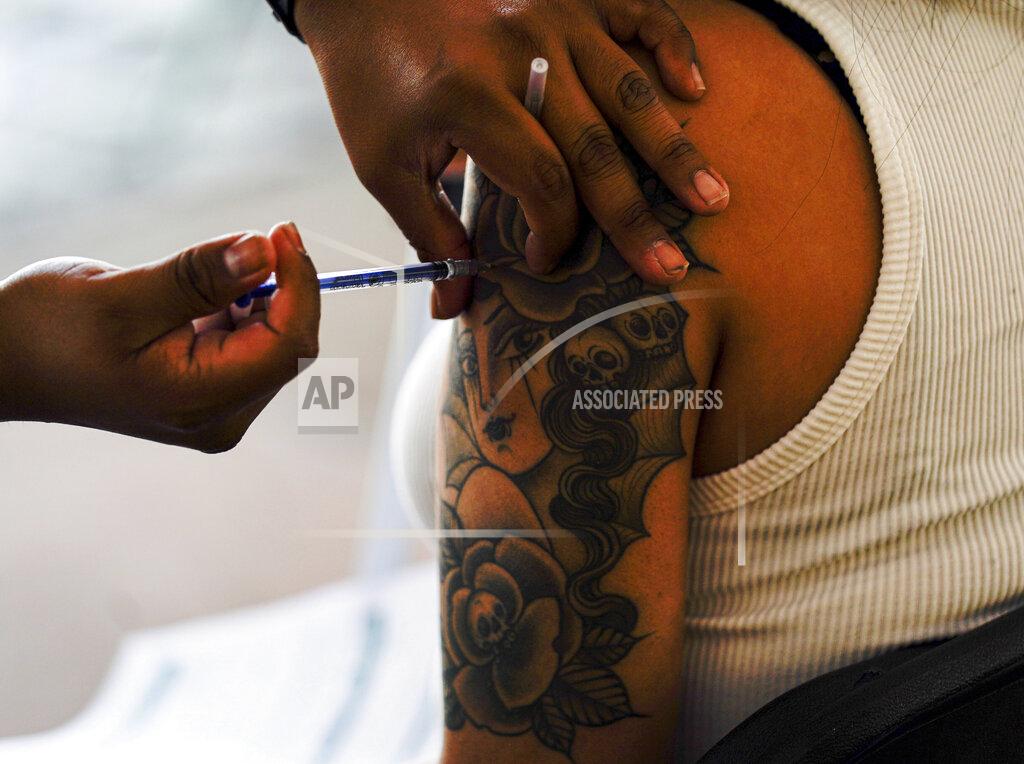 Fernando Llano A young woman gets her shot of Russia's Sputnik V coronavirus vaccine during a vaccination drive at University Stadium in Mexico City, Friday, July 23, 2021. So far, about 42.4 million people have been vaccinated, according to the health ministry. That is about 47% of the adult population, and about 30% of the total population. (AP Photo/Fernando Llano)