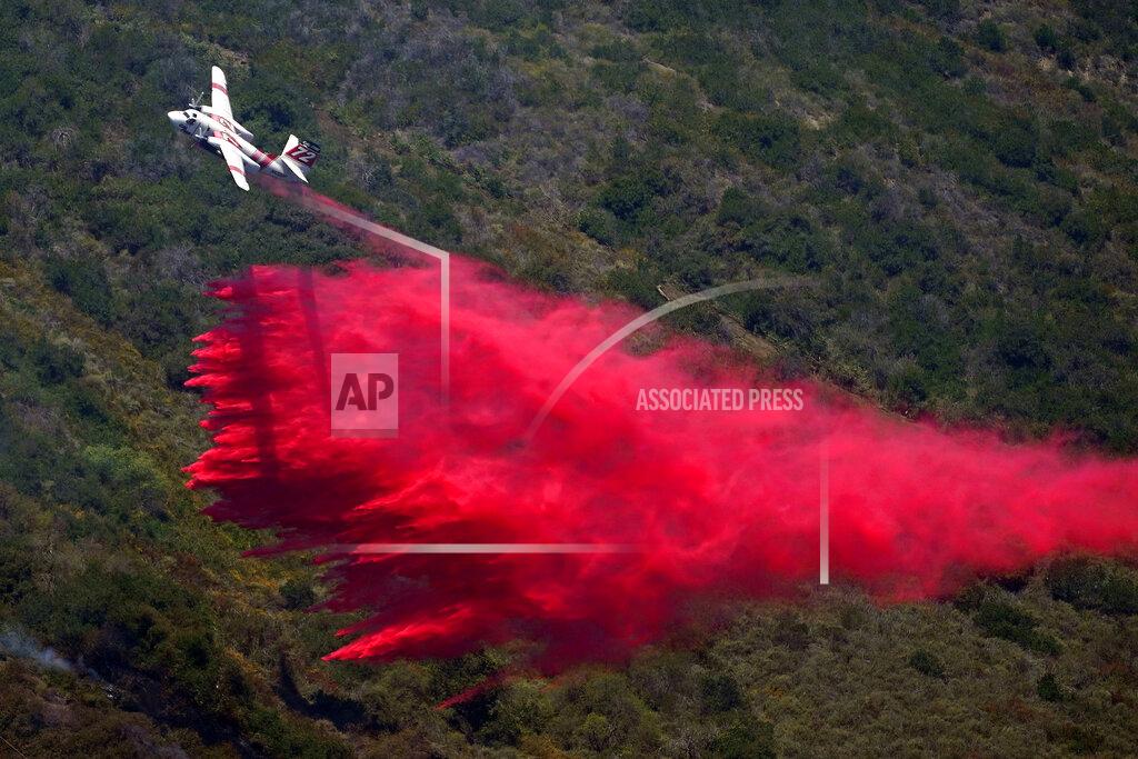 Marcio Jose Sanchez A plane drops fire retardant onto the Coastal Fire Thursday, May 12, 2022, in Laguna Niguel, Calif. (AP Photo/Marcio Jose Sanchez)