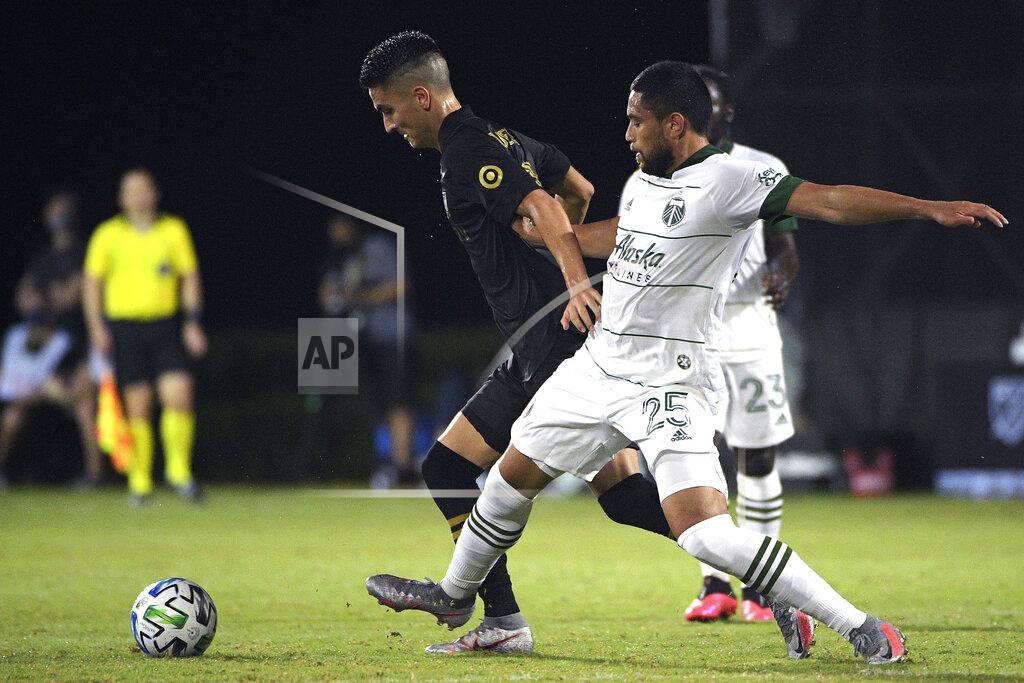Phelan M. Ebenhack Los Angeles FC midfielder Eduard Atuesta, left, and Portland Timbers defender Bill Tuiloma (25) compete for a ball during the second half of an MLS soccer match, Thursday, July 23, 2020, in Kissimmee, Fla. (AP Photo/Phelan M. Ebenhack)